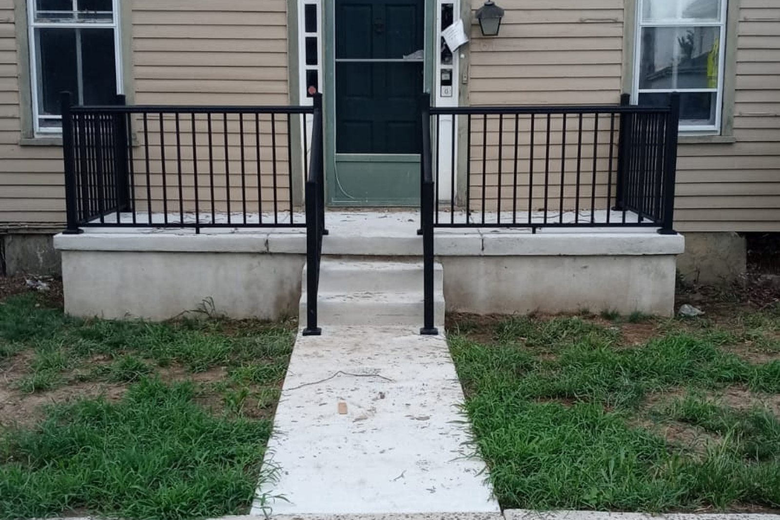 New concrete steps and a poured walkway leading to a front door